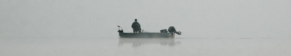 Image of a lone fisherman on a lake CC0