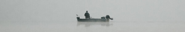 Image of a lone fisherman on a lake CC0